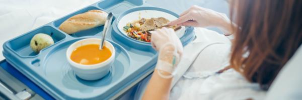 Sick woman in hospital getting food